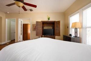 1 dormitorio con 1 cama y TV de pantalla plana en New! Spanish Gem-HotTub-Pool-Mins to River Walk, en San Antonio