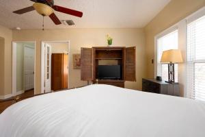 a bedroom with a bed and a flat screen tv at New! Spanish Gem-HotTub-Pool-Mins to River Walk in San Antonio