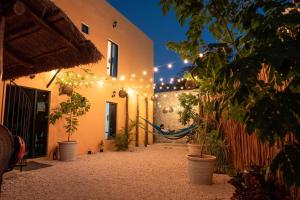 a courtyard with a hammock in a building with lights at New friends hostel & Bar Adults Only in Valladolid