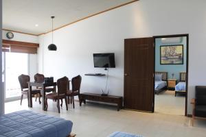 a living room with a dining room table and a bedroom at Winners Residence in Saipan