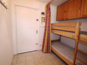 a room with two bunk beds and a door at Appartement Le Grau-du-Roi, 2 pièces, 6 personnes - FR-1-307-8 in Le Grau-du-Roi