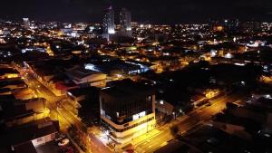 una ciudad de noche con edificios y luces en Apartahotel Altos de la Sabana en San José