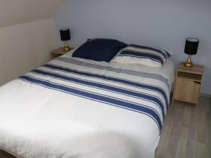 een bed met blauwe en witte lakens en twee lampen bij Maison Erdeven, 3 pièces, 4 personnes - FR-1-479-108 in Erdeven