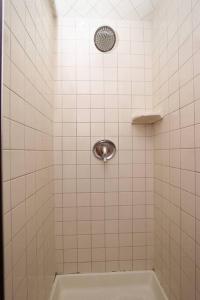 a white tiled shower with a shower head at 15 min Ohare/Rivers Casino/Downtown & Parking2 in Chicago