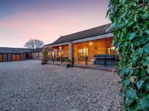 an exterior view of a building with a gravel driveway at Barn House in Friskney