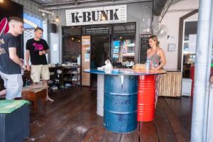 a group of people standing around a table in a store at K-Bunk Hostel in Ao Nang Beach