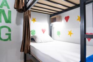 1 dormitorio con 1 cama con corazones en la pared en K-Bunk Hostel en Ao Nang