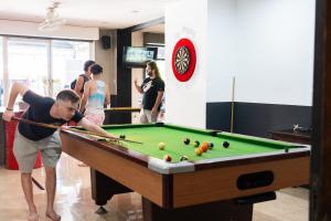 a man playing a game of pool in a room at K-Bunk Hostel in Ao Nang Beach