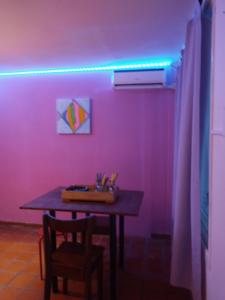 a purple room with a table and a purple light at ALOHA HOSTEL by BUDA BEACH in Puerto Pirámides +78 photos