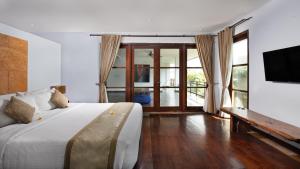 Danoya Private Luxury Residences في سمينياك: غرفة نوم بسرير كبير وتلفزيون