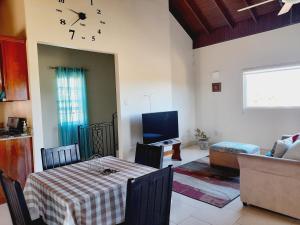ein Wohnzimmer mit einem Tisch und einer Uhr an der Wand in der Unterkunft Ultimate Chill Montego Bay in Montego Bay