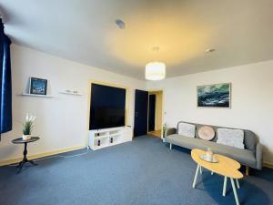 a living room with a couch and a flat screen tv at Spacious and beautiful apartment in the center of Frederikshavn in Frederikshavn