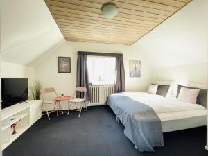 a bedroom with a large bed and a television at Spacious and beautiful apartment in the center of Frederikshavn in Frederikshavn