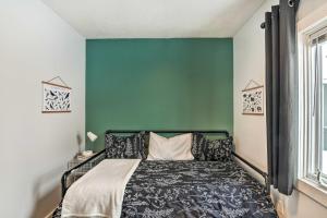 1 dormitorio con 1 cama con pared verde en Anchorage Home, Minutes From Downtown! en Anchorage