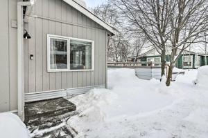 a house with snow on the ground next to a window at Anchorage Home, Minutes From Downtown! in Anchorage