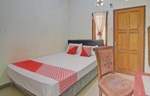 sypialnia z łóżkiem, krzesłem i drzwiami w obiekcie SPOT ON 92281 Susupuan Kost w mieście Tondano
