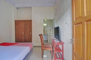 sypialnia z łóżkiem i biurkiem z telewizorem w obiekcie SPOT ON 92281 Susupuan Kost w mieście Tondano