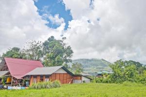 een huis met een rood dak in een veld bij SPOT ON 92281 Susupuan Kost in Tondano