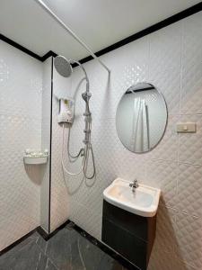 Un baño con ducha, lavabo y espejo. en DiscoveryHome at Pratunam market, en Bangkok