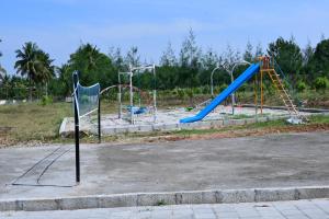 un parque con parque infantil con toboganes y columpios en Encanto Farmstay en Mysore