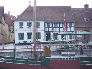 een boot is aangemeerd in een haven met gebouwen bij Restaurant Sælhunden in Ribe