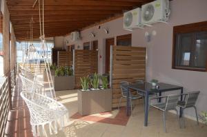 un patio con mesa, sillas y plantas en Evgenia & Zoe Apartments, en Nea Vrasna