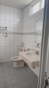 a white bathroom with a toilet and a sink at Swallow homestay in Taitung City