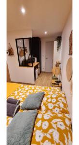 - une chambre dotée d'un lit avec une couverture jaune et blanche dans l'établissement La suite d'Arches, à Charleville-Mézières