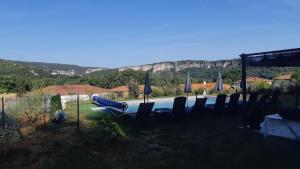 een zwembad met stoelen en parasols in een tuin bij Villa d'Olt in Saint-Géry