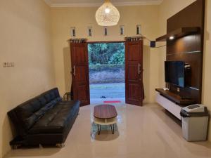 ein Wohnzimmer mit einer Couch und einem Couchtisch in der Unterkunft D'Aurora Homestay in Timuran