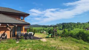 - Vistas a una casa con sillas y parque infantil en Vila nad Liptálem - Celý objekt, poblíž domu je rekreační oblast Všemina, en Vsetín