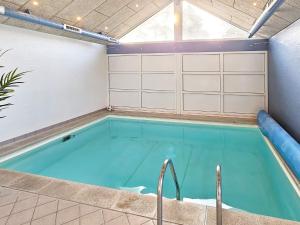 uma grande piscina com uma grande janela em Four-Bedroom Holiday home in Hadsund 26 em Nørre Hurup