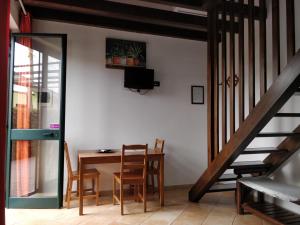 una sala da pranzo con tavolo, sedie e scala di Agriturismo Fratelli Mizzon a Sabaudia