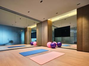 a yoga room with yoga mats and a flat screen tv at The QUBE Hotel Ningbo North in Ningbo