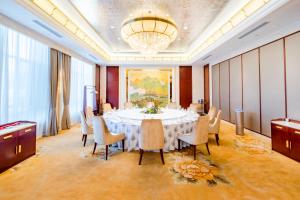a large dining room with a table and chairs at 潍坊富华大酒店a座 in Weifang