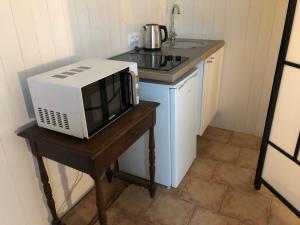 a microwave sitting on a table next to a sink at La Saulainière in Pontlevoy