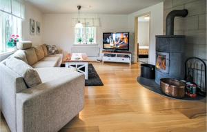 sala de estar con sofá y chimenea en 5 Bedroom Pet Friendly Home In Strmsnsbruk, en Strömsnäsbruk