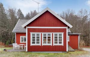 una casa roja con una mesa y sillas frente a ella en 5 Bedroom Pet Friendly Home In Strmsnsbruk, en Strömsnäsbruk