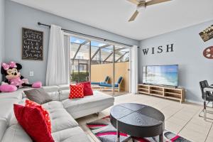 a living room with a white couch and a tv at The Wish House, just miles from Disney World in Orlando