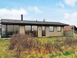 a house on top of a grass field at 5 person holiday home in Harbo re in Harboør