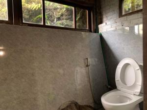 a bathroom with a toilet and two windows at Chapi Dreamy Home in Sa Pa