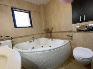 a bathroom with a large white tub and a toilet at Penthouse City Centre in Iaşi +26 photos