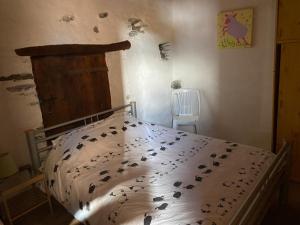 a bedroom with a bed with a comforter with birds on it at LA VIEILLE FERME in Err
