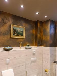 a bathroom with a painting on the wall at Apartment Alte Schusterei in Freiberg