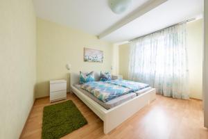 a bedroom with a bed and a green rug at Ferienhaus Hunsrückliebe in Liederbach