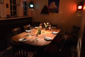 una mesa de madera con copas de vino y flores. en Restaurant Sælhunden en Ribe