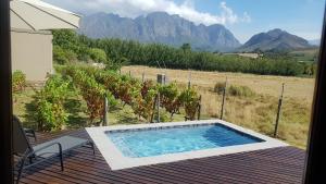 a swimming pool on a deck with a view of a mountain at Cottage K'Gari in Franschhoek