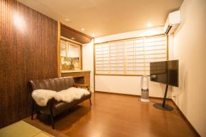 京都喜楽・翡翠的带椅子和电视的客厅