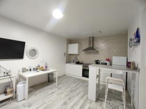 a kitchen with white cabinets and a table and chairs at Apto con Hidromasaje sweet Charco by flamingo house in Arrecife