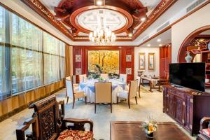 uma sala de jantar com uma mesa e um lustre em 潍坊富华大酒店b座 em Weifang